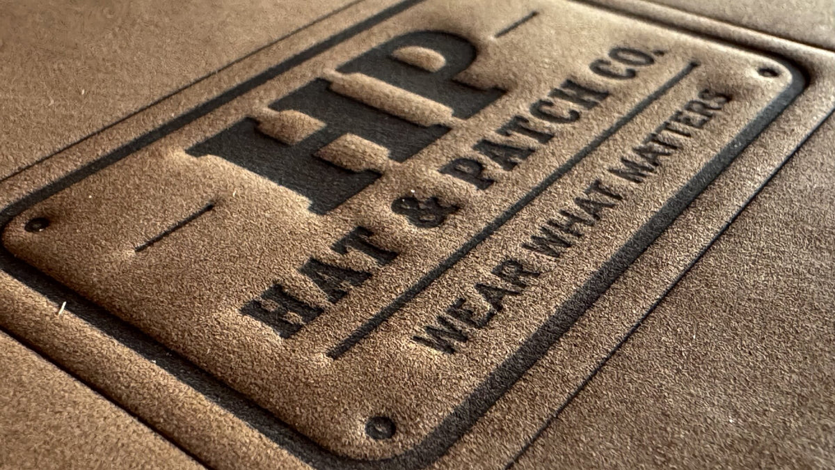 Full-grain leather patch, heat-stamped with the Hat & Patch Co. logo