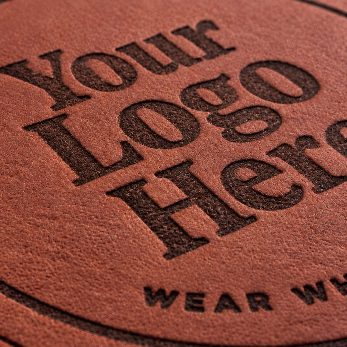 A "Your Logo Here" design heat-stamped into a red-brown full-grain leather patch