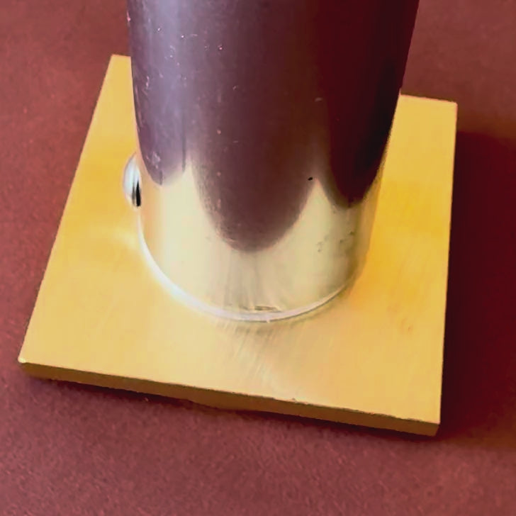 Heated brass die pressing "Your Logo Here" into a full-grain leather patch